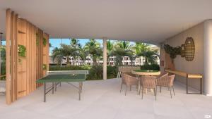 un patio con mesa de ping pong y sillas en Mana Beach Resort By Smart Stays, en Porto de Galinhas
