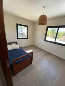 1 dormitorio con 1 cama y 2 ventanas en Casa en Country en Yerba Buena