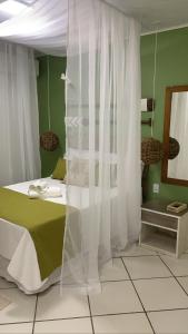 a bedroom with a bed with a white curtain at Recanto do Sol in Praia de Araçatiba