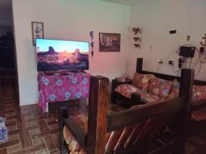a living room with a flat screen tv and a couch at Hostel Raio de Fogo in Paraty
