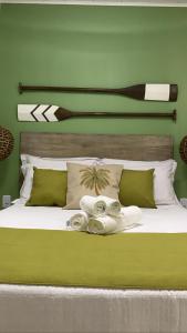 Un dormitorio verde con una cama con toallas. en Recanto do Sol, en Praia de Araçatiba