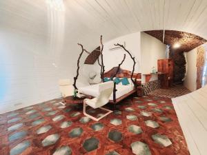 um quarto com uma cama e duas cadeiras em Obrigado by Craftels em Cabo de Rama