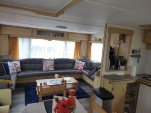 a living room with a couch and a table at The Rabbit Hill Holiday Home in Ballantrae
