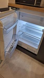 - un réfrigérateur vide avec une porte ouverte dans la cuisine dans l'établissement Apartament Pod Brzyzkiem, à Leśnica