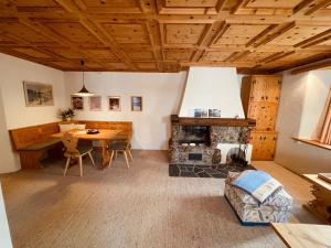 a living room with a table and a fireplace at Chesa Coronella in La Punt-Chamues-ch