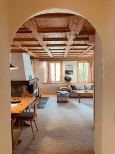 an archway in a living room with a couch and a table at Chesa Coronella in La Punt-Chamues-ch