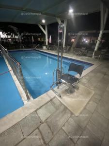 uma piscina à noite com uma cadeira ao lado em Casa para até 10 pessoas DiRoma Fiori Caldas Novas - YMT - 417 em Caldas Novas