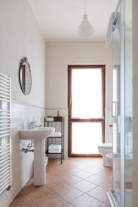 a bathroom with a sink and a toilet and a window at Dolce Sosta in Lucca