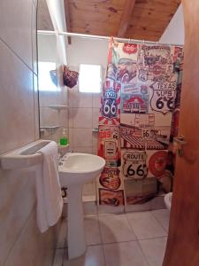a bathroom with a sink and a shower curtain at Cabañas Mérida Ruta 66 in El Hoyo