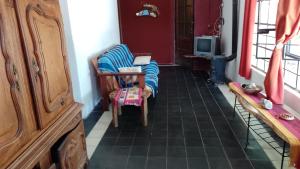 uma sala de estar com uma cadeira e uma televisão em La Casa De La Gruta em Mina Clavero