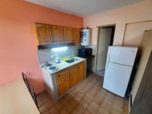 uma cozinha com um frigorífico branco e um lavatório em Departamento en Mendoza Capitál em Mendoza