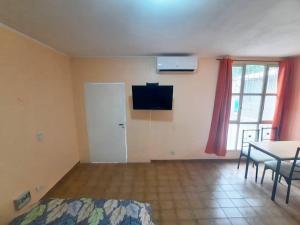 Departamento en Mendoza Capitál في ميندوزا: غرفة بسرير وطاولة وتلفزيون