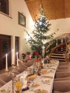 una mesa larga con un árbol de Navidad en una habitación en Villa la Val, Karkonosze, en Szarocin