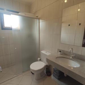 y baño con aseo, lavabo y ducha. en Casa de 2 Quartos na Praia da Joaquina, en Florianópolis
