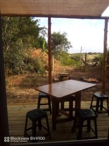 einen Tisch und zwei Stühle auf einer Veranda mit einem Fenster in der Unterkunft Casita entre dunas al son del mar in Salinas