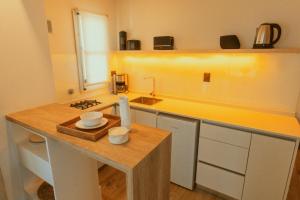 a kitchen with a sink and a counter with two cups at La Galeria - Hotel Boutique Cariló in Carilo