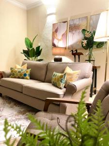 a living room with a couch and some plants at Villa Ruby - with private swimming pool in Kota Bharu