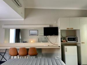 um quarto com uma cama, 2 cadeiras e um micro-ondas em Tarra Motel em Yarram