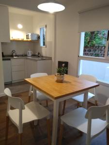 cocina con mesa de madera y sillas blancas en departamentos del mar-Solo familias en Mar del Plata