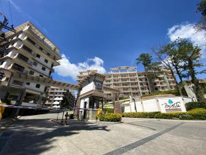 a large apartment building in front of a building at Condo Suite Near JohnHay MinesView TheMansion in Baguio