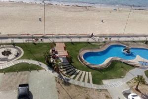 a swimming pool next to a beach with a bridge at Apartamento junto a la playa - Vistas Increíbles in Coquimbo