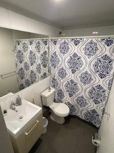 a bathroom with a toilet and a sink and blue and white tiles at Apartamento junto a la playa - Vistas Increíbles in Coquimbo