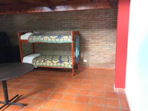 富內斯的住宿－Casa Departamento Funes Bella Vista Wifi Cochera Pileta，砖墙内带两张双层床的房间