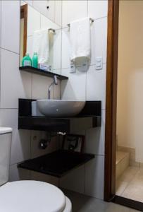 La salle de bains est pourvue d'un lavabo et de toilettes. dans l'établissement Aconchego Premium, à Angra dos Reis