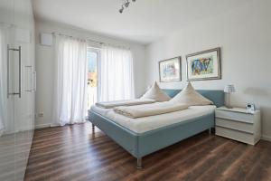 Schlafzimmer mit einem Bett in Blau und Weiß in der Unterkunft Cara in Garmisch-Partenkirchen