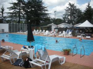 una piscina con sedie, ombrelloni e persone che nuotano di Nostra Signora Del Lago a Ronciglione Altre 24 foto