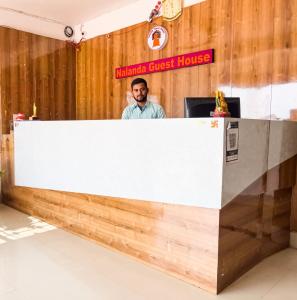 a man standing behind a reception desk at Hotel Nalanda Guest House in Nalanda