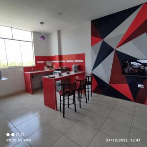 a kitchen with a counter and some chairs in it at Departamento-Natural M4 in Chiclayo