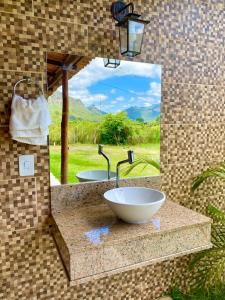 a bathroom with a bowl sink and a mirror at Casa de Campo - Rancho Braga Aguiar in Ibicoara