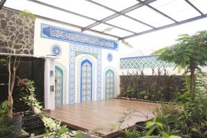 a building with blue and white tiles on the wall at Bu Sepuh GuestHouse in Sangkanurip