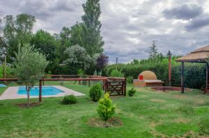a garden with a swimming pool and a gazebo at Complejo BenjaLuna in San Rafael