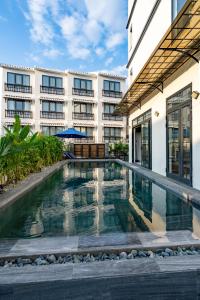 a swimming pool in front of a building at The Present River Villa Hoi An in Hoi An