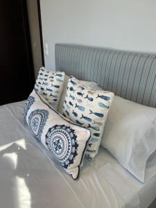 eine Gruppe von Kissen auf dem Bett in der Unterkunft Magical Seaside Town Boutique Apts 2 in Kyparissia