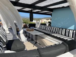 einen Balkon mit schwarzen und weißen Stühlen und einem Tisch in der Unterkunft Magical Seaside Town Boutique Apts 2 in Kyparissia