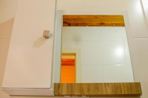 a mirror in a white room with a hallway at Pousada Sítio Do Trevo in Urubici