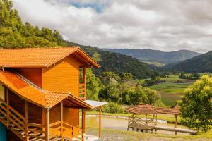 a wooden cabin with a view of a valley at Pousada Sítio Do Trevo in Urubici