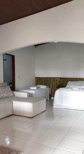 Fazenda Hotel Bem Ecológico في Planaltina: غرفه فيها ثلاث اسره واريكه