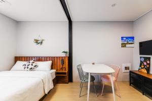 Schlafzimmer mit einem Bett und einem Tisch in der Unterkunft Well stay in Incheon