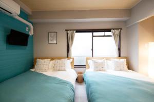 1 Schlafzimmer mit 2 Betten und einem Fenster in der Unterkunft akihabara marutomo hotel in Tokio