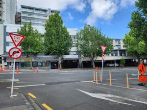 una calle vacía con señales de construcción frente a un edificio en Newton Lodge Auckland, en Auckland