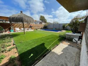 einen kleinen Hinterhof mit Rasen und Sonnenschirm in der Unterkunft Casa de totys en la Serena in La Serena