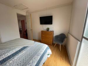 ein Schlafzimmer mit einem Bett, einer Kommode und einem TV in der Unterkunft Casa de totys en la Serena in La Serena