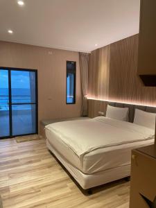 鹽寮村的住宿－礁岩海灣主題民宿，一间卧室设有一张大床和一个大窗户