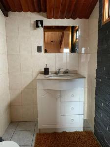 uma casa de banho com um lavatório branco e um espelho. em Casa Centro Dalcahue em Dalcahue