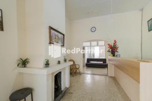 a living room with a fireplace and a table at Pondok Cahaya Panorama Mitra RedDoorz in Lembang