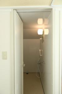 een badkamer met een douche en een glazen deur bij Mkグリーンホテル in Kawaguchi